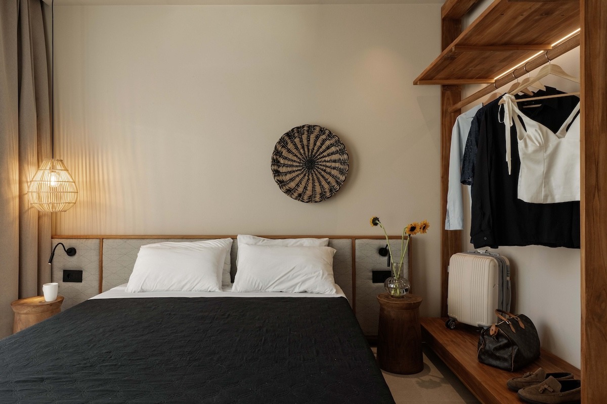 Luxury villa bedroom with double bed, natural materials, and minimalist Mediterranean interior in Rhodes